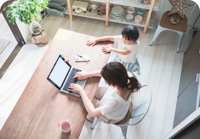 ママフリーランスとして起業したての女性が自宅で育児しながら仕事をする様子